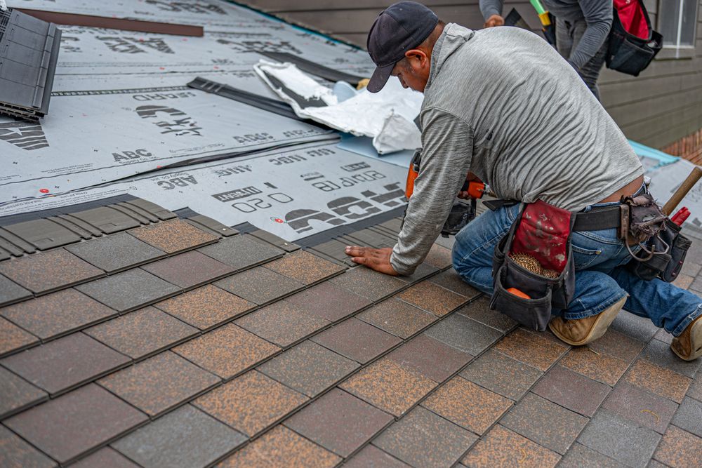 Roofer installing asphalt shingles